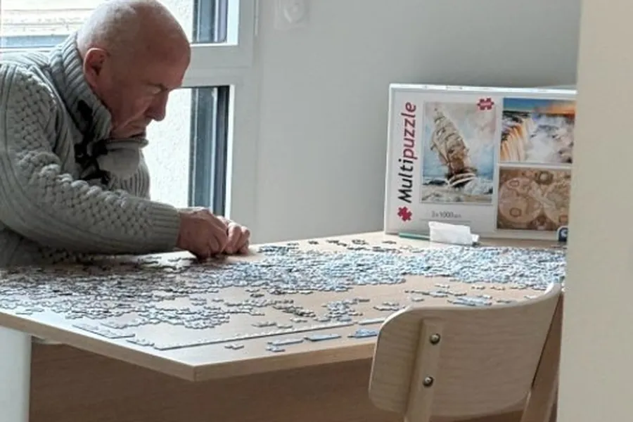 Personne âgée concentrée sur un puzzle lors d'un atelier AUXI'life