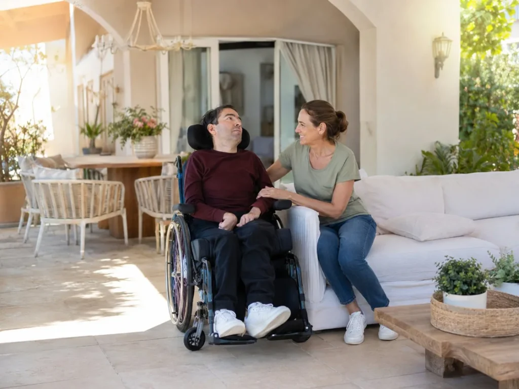 Un homme atteint d'une maladie invalidante échange avec sa compagne sur la terrasse de son domicile