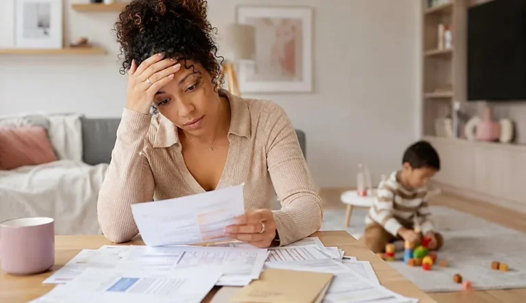 Avance immédiate crédit d’impôt : une mère gère ses papiers d’aide à domicile, son enfant joue à côté