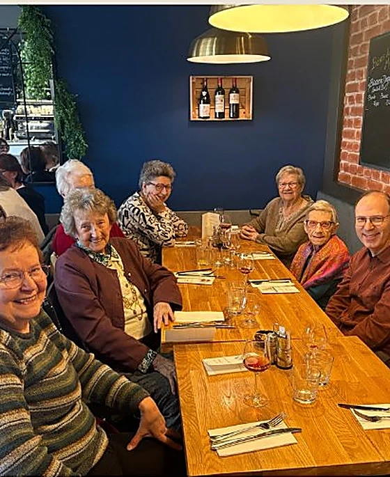 Un moment convivial au restaurant entre des personnes âgées et le Réseau AUXI'life, reflet de nos engagements au-delà des gestes du quotidien