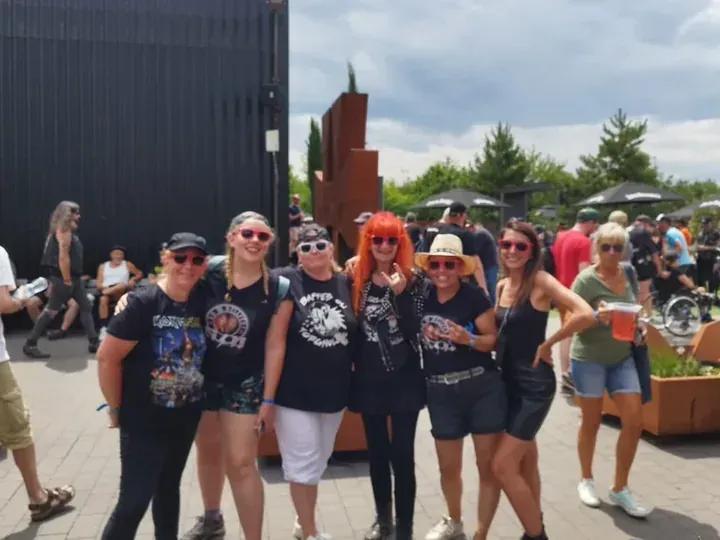 Un groupe de festivaliers réunis dans une ambiance conviviale lors d'un festival de metal soutenu par le Réseau AUXI'life