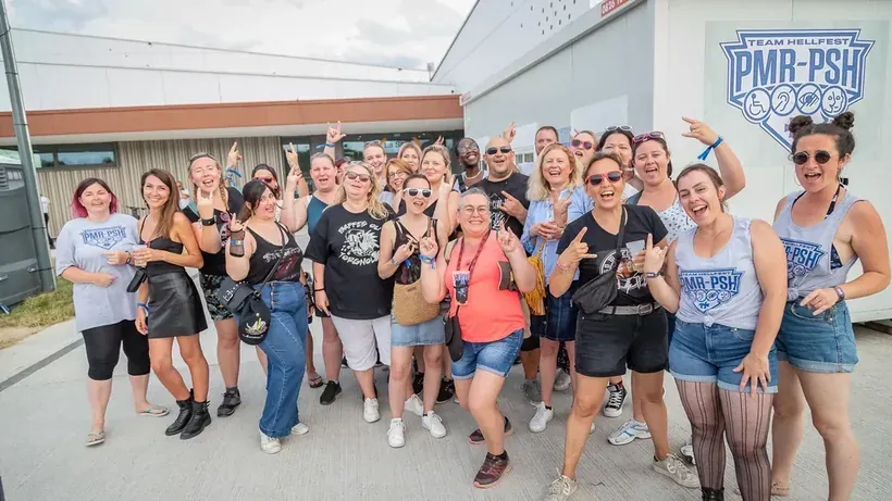 L'équipe bénévole de la Team PMR-PSH du Hellfest, soutenue par le mécénat handicap du Réseau AUXI'life, réunie devant le festival