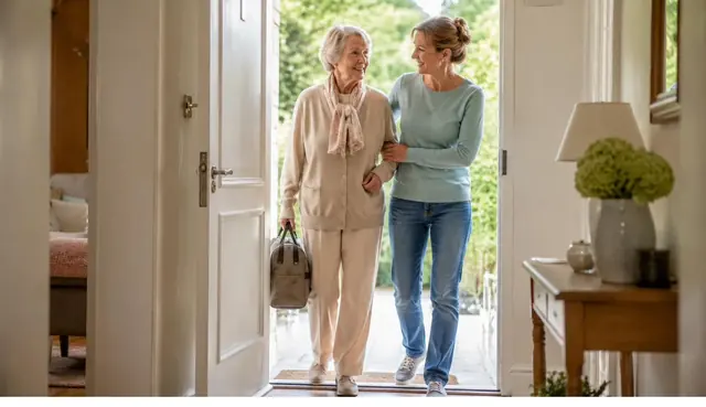 Une personne âgée rentre chez elle, accompagnée, après une hospitalisation